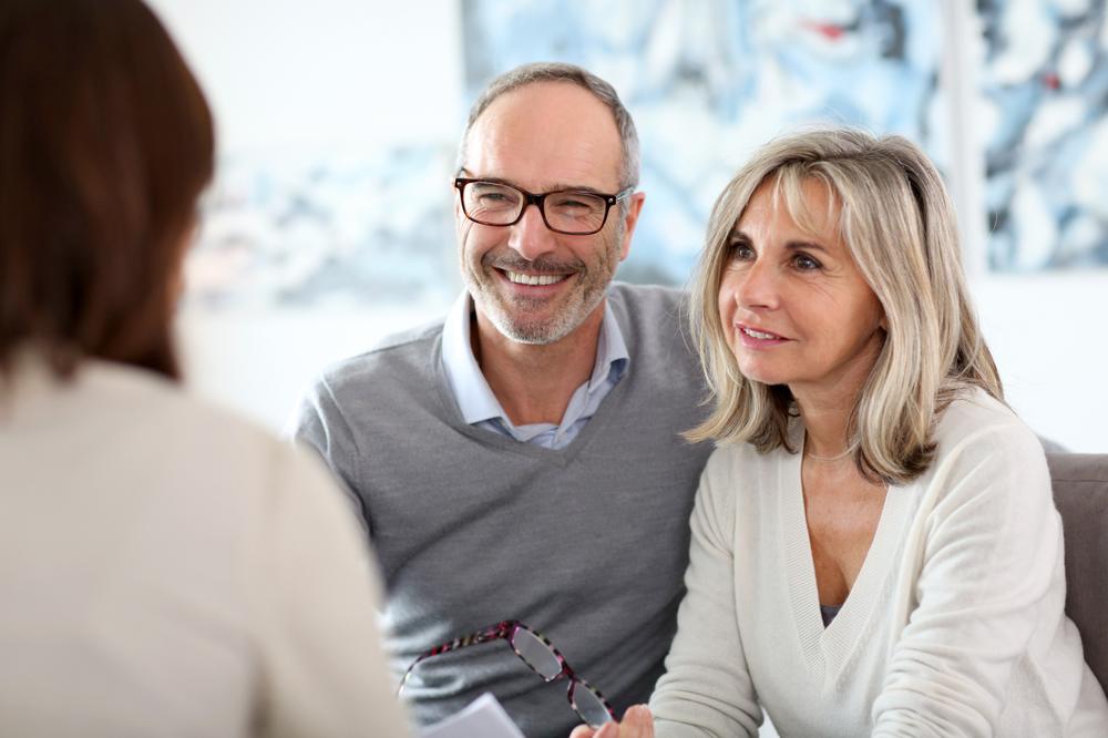 couple souriant écoutant le conseiller 